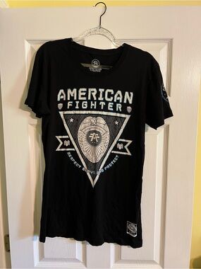 Women’s American Fighter Black Tee with White and Blue Badge Graphic